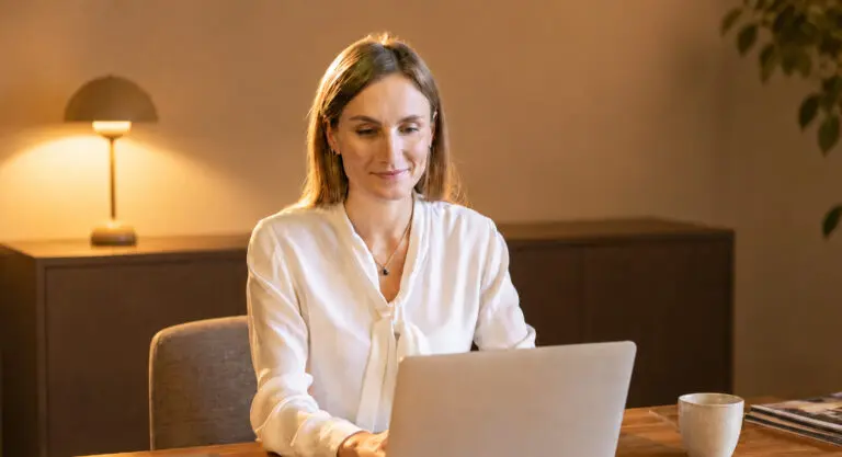 vrouw die aan een tafel met laptop zit te werken