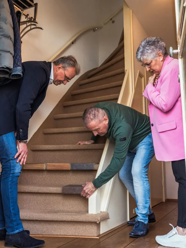 adviseur legt decors op de trap bij mensen thuis