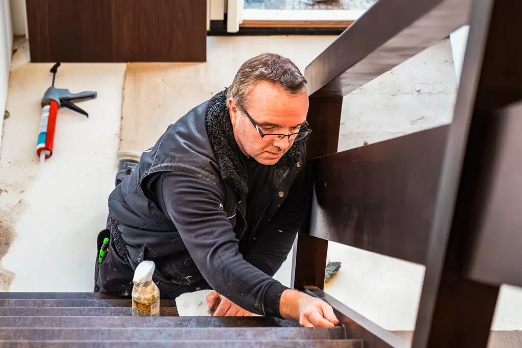 monteur is de stootborden aan het afkitten in de trap