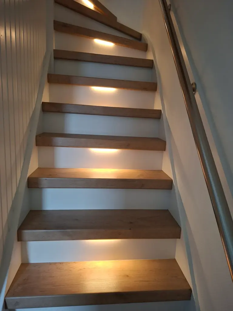 vooraanzicht van gerenoveerde trap in decor Toscana. De verlichting staat aan.